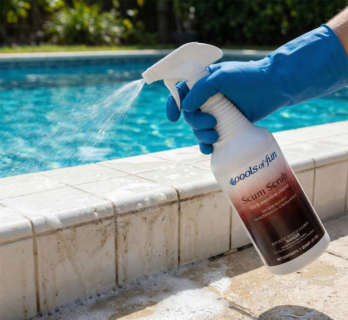 Person wearing blue gloves using a spray bottle labeled 'Scrub Scrub' byools of fun on a pool ledge.