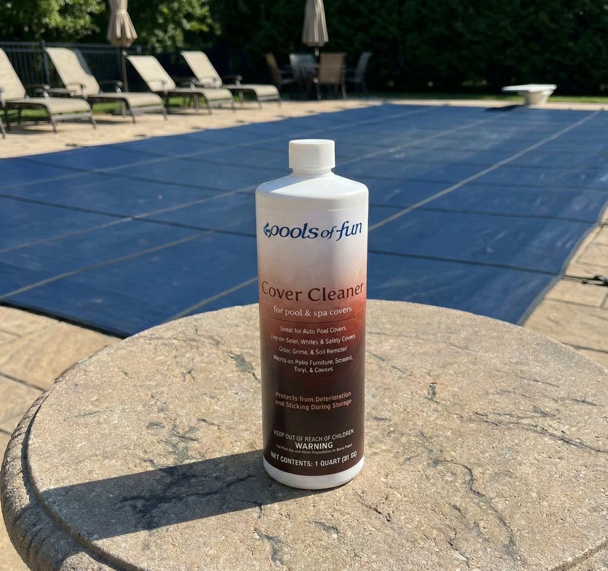 Bottle of pool cover cleaner on a stone surface with a pool in the background