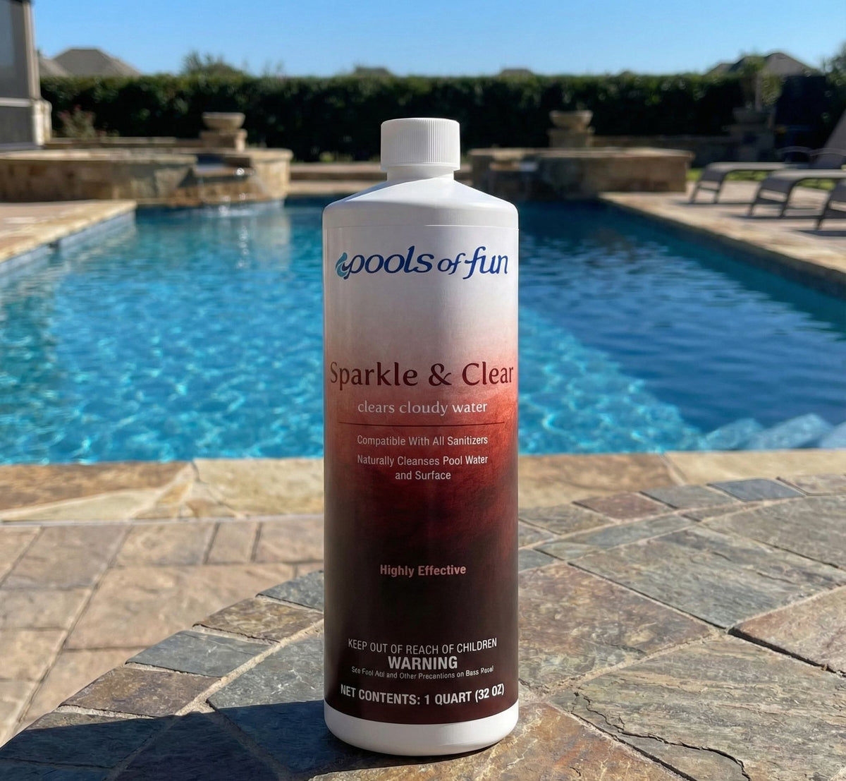 Bottle of 'Pools of Fun Sparkle & Clear' pool cleaner on a patio with a pool in the background.