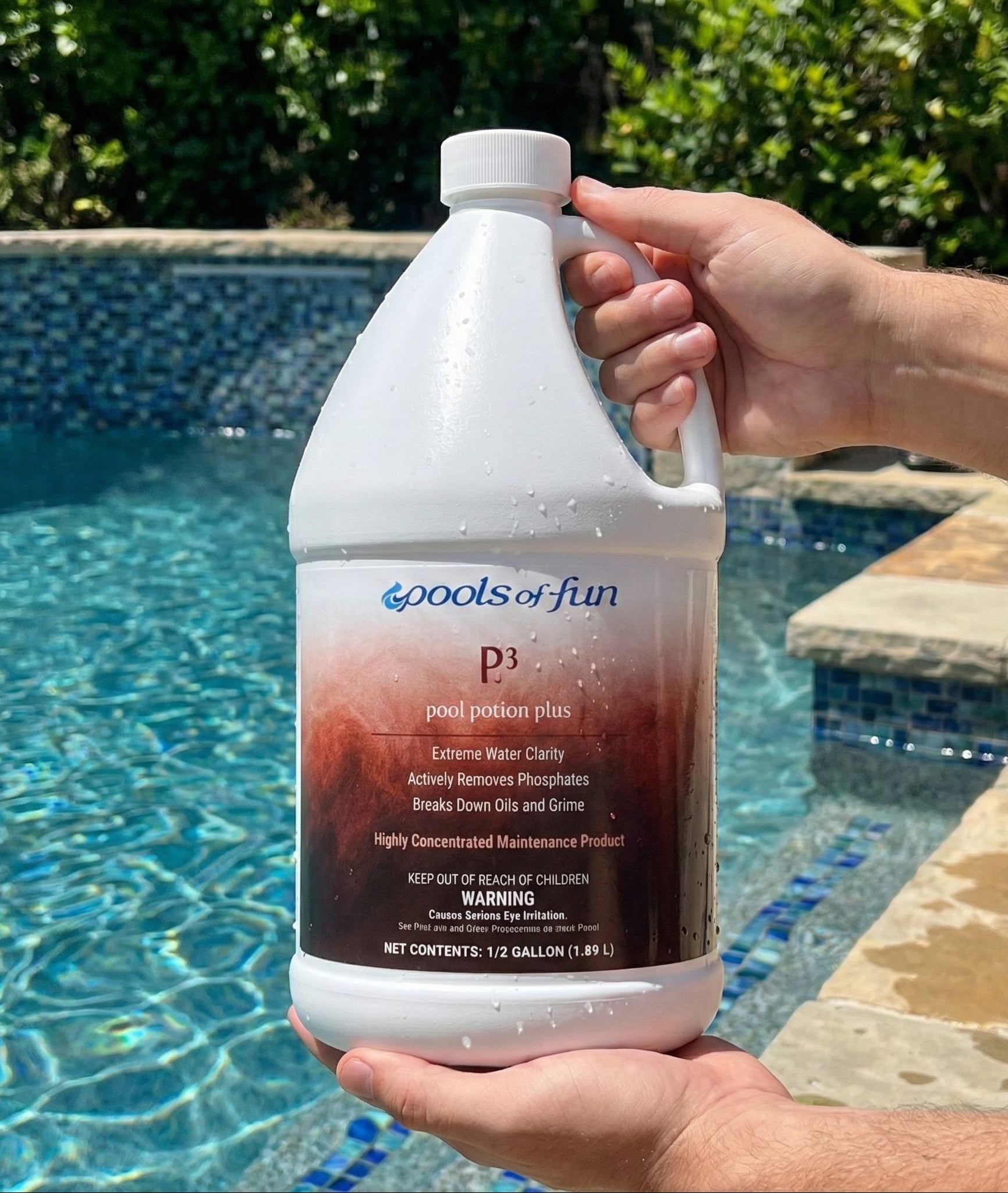 Person holding a bottle of 'Pools of Fun' pool treatment product by a pool.