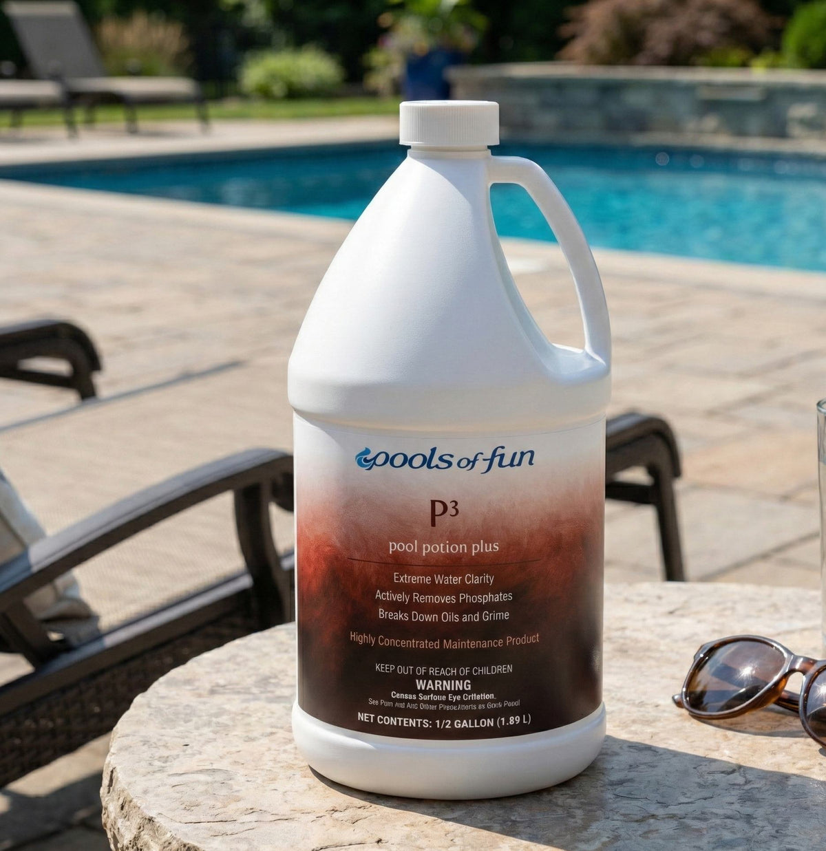 Gallon jug of 'Pools of Fun' pool treatment product on a table by a pool.